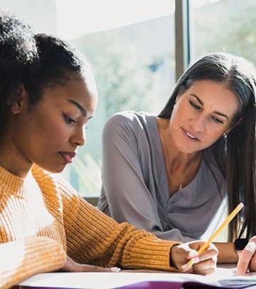 Counselor helping student at table