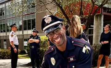 Officer Coleman in foreground with other officers and students talking in background